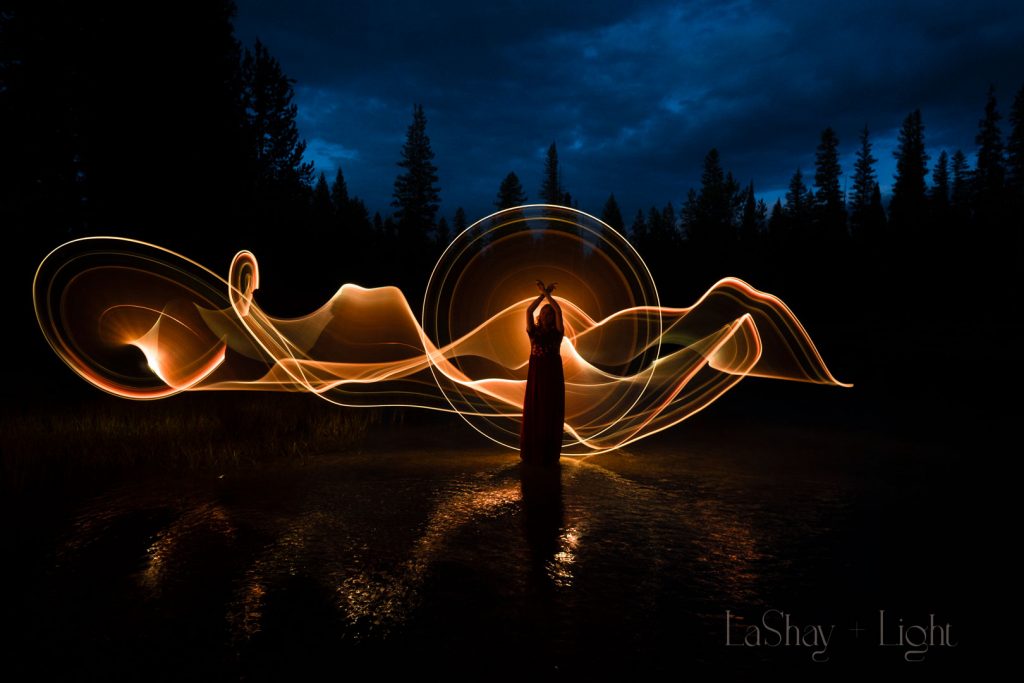 silhouette of woman in front of golden light painting outdoors