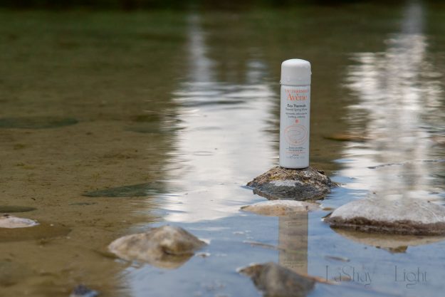 avene thermal water product on a rock in the water
