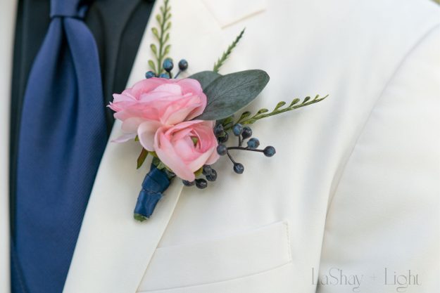 wedding detail shot of the groom's pink boutonniere 