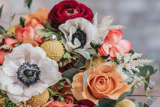 closeup of colorful wedding flowers with wedding ring inside
