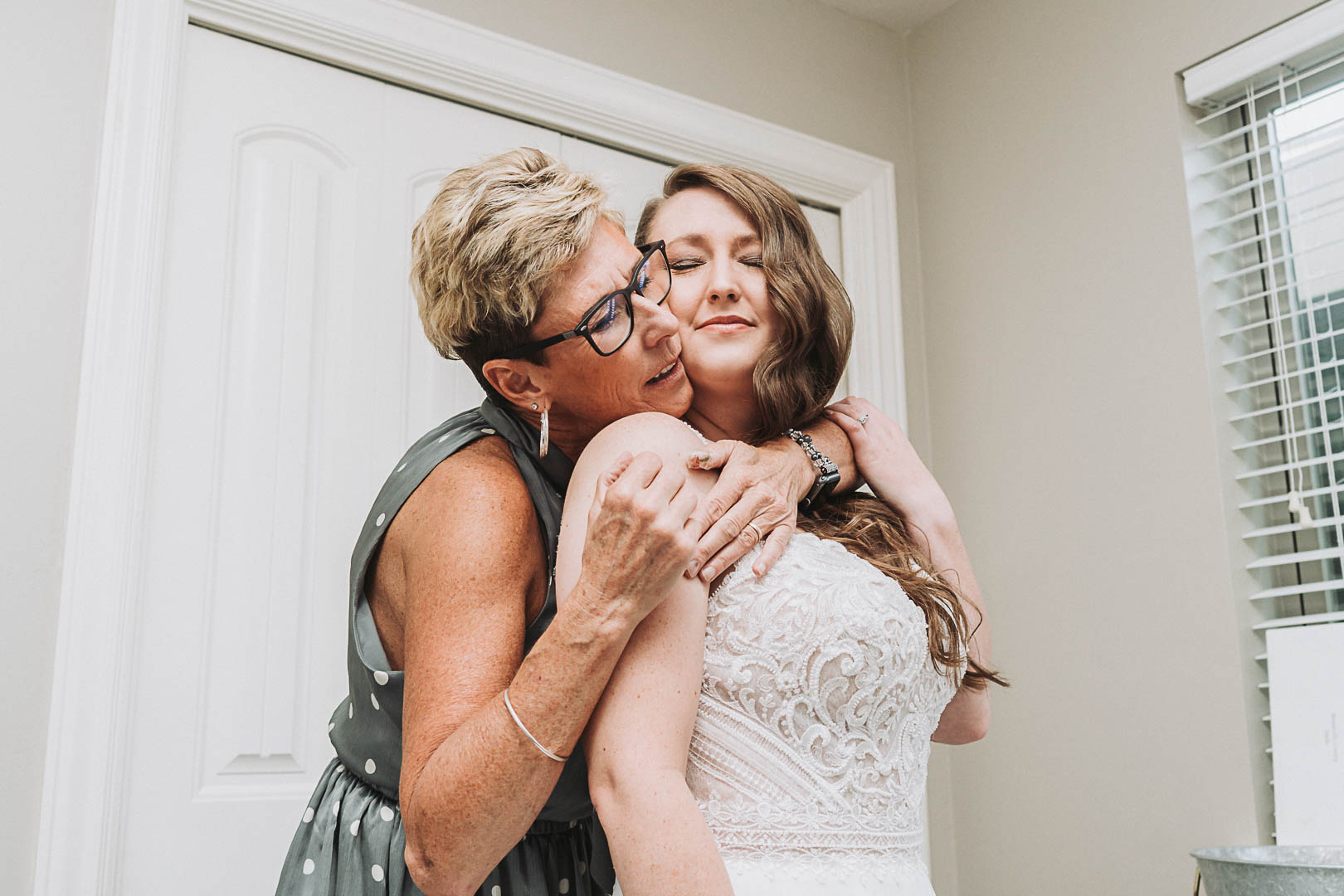 mom hugging bride as she's getting ready