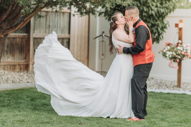 bride and groom kissing at a backyard wedding eloping vs. wedding