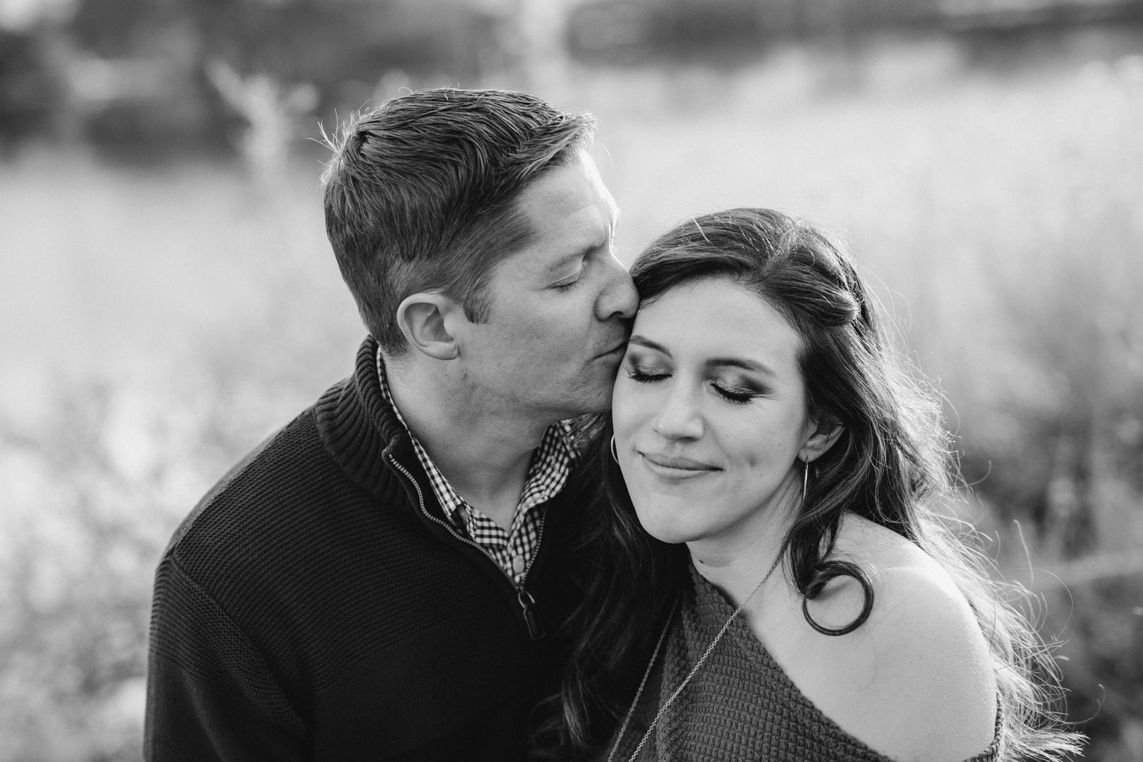 cinematic engagement photoshoot man kissing woman on temple