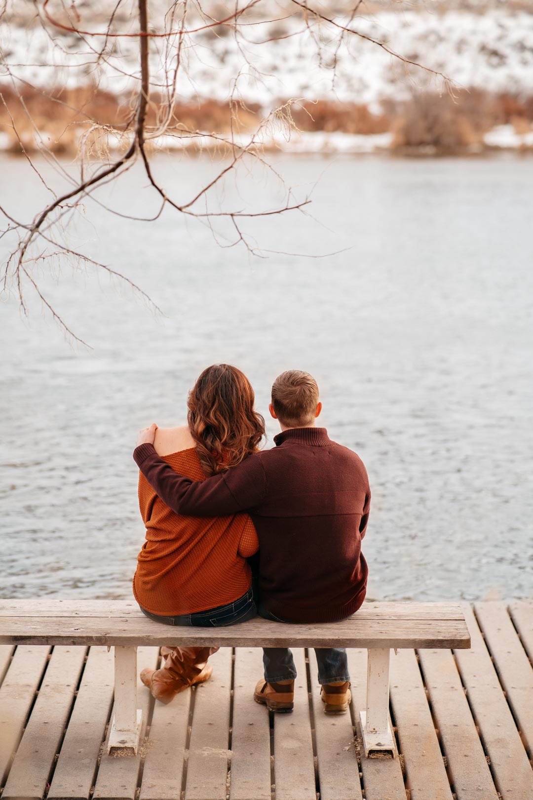 couple sitting on a bench looking at snake river idaho