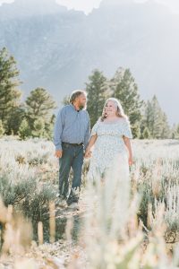 couple walking together through meadow
