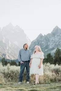 couple looking at each other with grand teton mountains