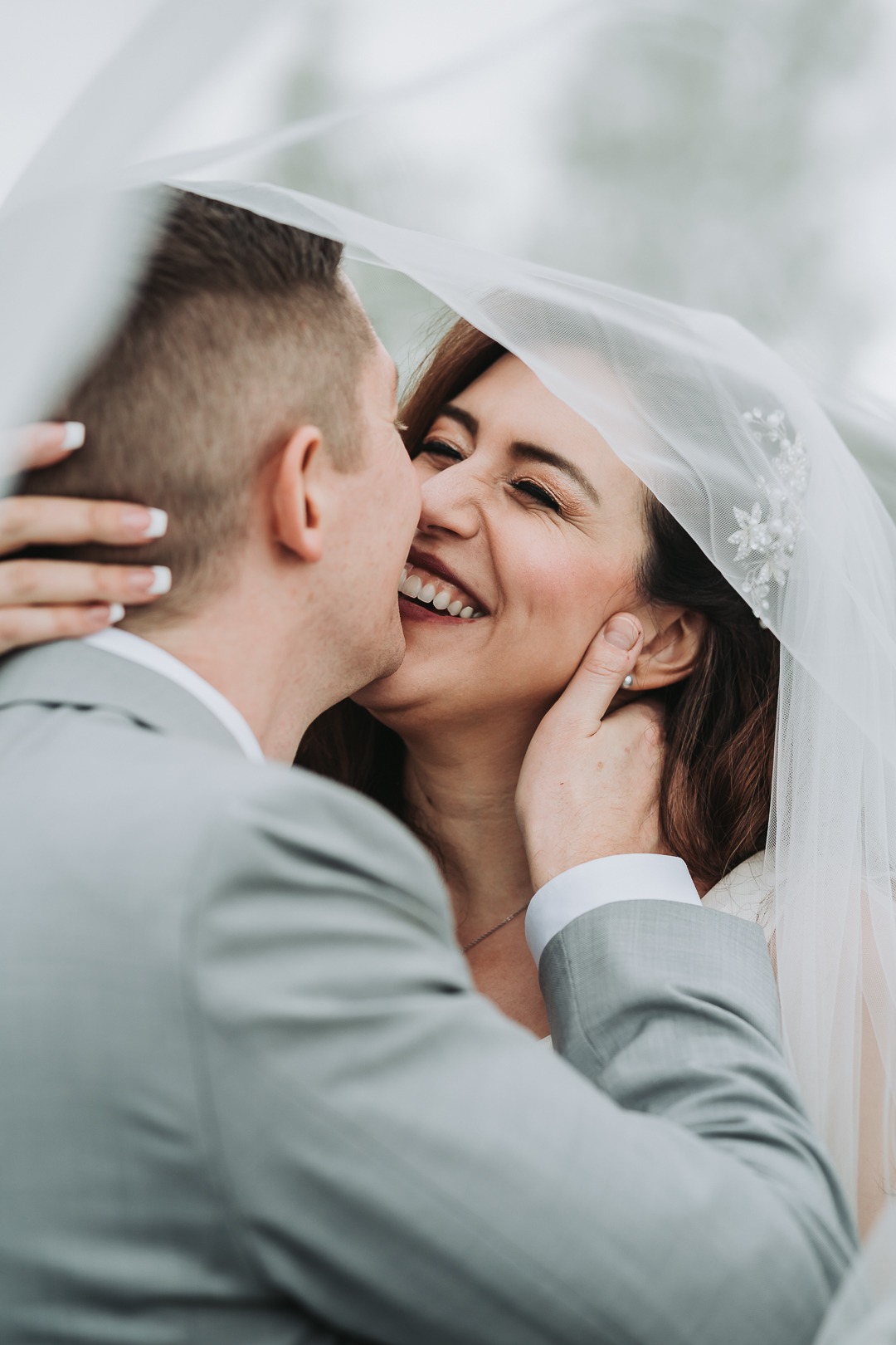 bride and groom smiling under the veil boise idaho wedding photographer