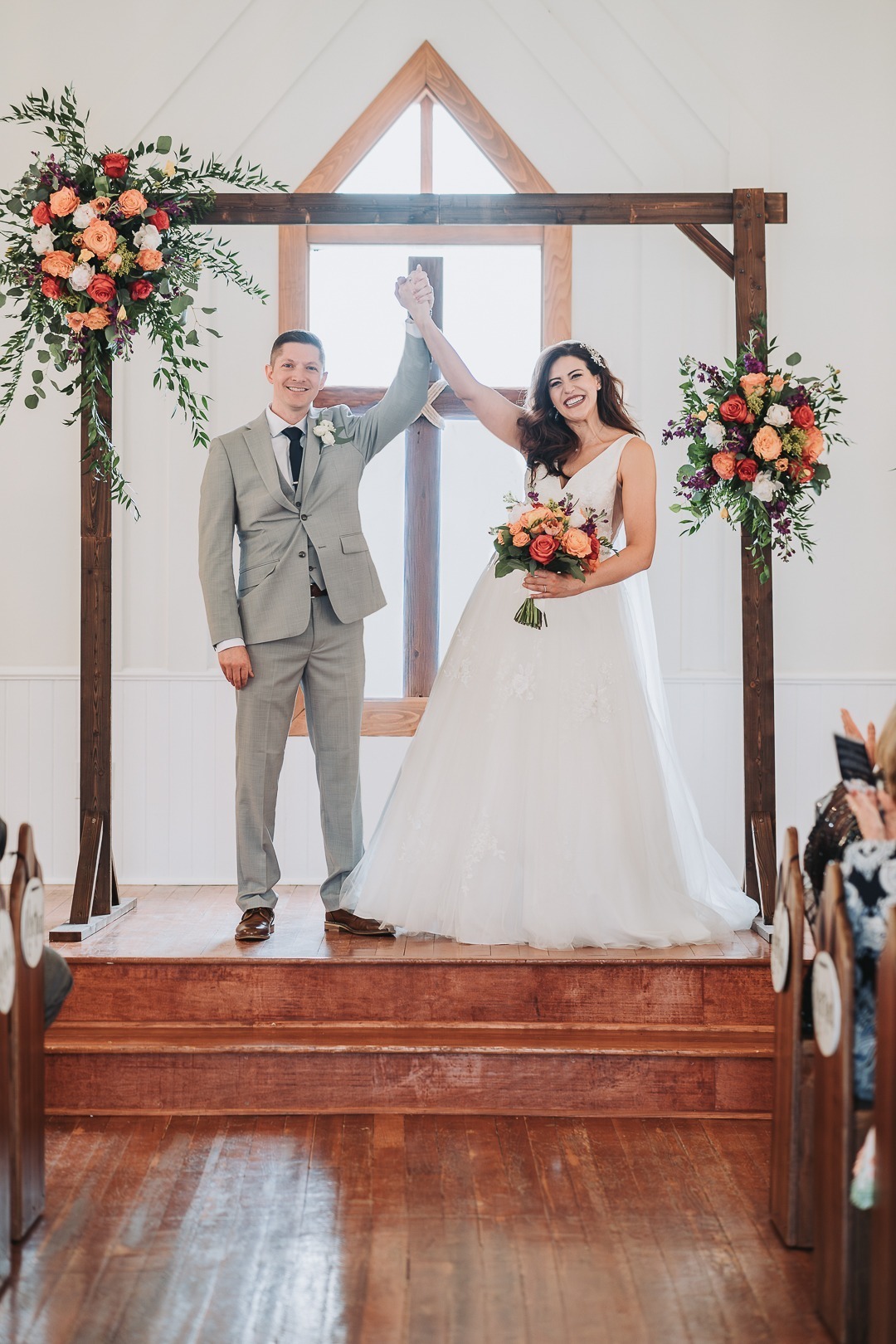 married bride and groom holding hands up after reception