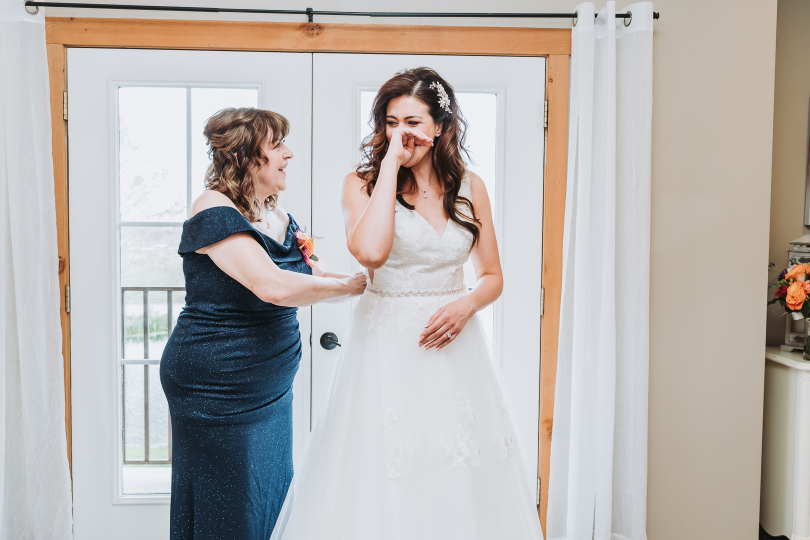 Documentary wedding photography with bride crying as the mom helps her dress
