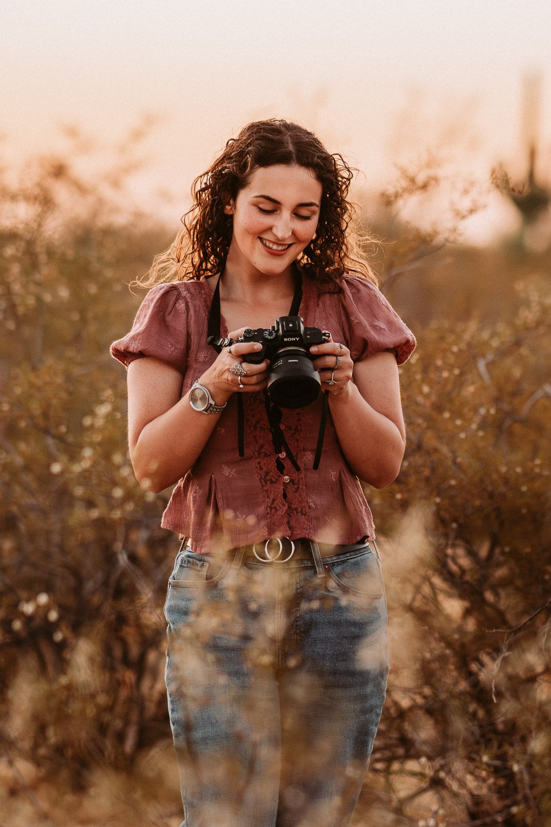 tucson photographer looking at her camera smiling